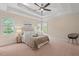 Primary bedroom boasts a trey ceiling, plush carpet, and natural light from surrounding windows at 1504 Haventree Rd, Durham, NC 27713