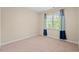 Neutral-toned bedroom with carpeted floor and large window at 1504 Haventree Rd, Durham, NC 27713