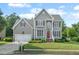 Charming two-story home with gray siding, manicured lawn, and mature landscaping at 1504 Haventree Rd, Durham, NC 27713