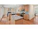 Open concept kitchen with island, stainless appliances, and adjacent living room at 1504 Haventree Rd, Durham, NC 27713