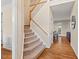 Carpeted staircase with wood handrail leads to the upper level, adjacent to the dining area at 1504 Haventree Rd, Durham, NC 27713