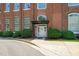 Charming brick building entrance with bushes and a welcoming white door with black awning at 1535 Caraleigh Mills Ct # 210, Raleigh, NC 27603