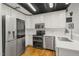 Modern kitchen with stainless steel appliances, white cabinets and hardwood floors at 1535 Caraleigh Mills Ct # 210, Raleigh, NC 27603