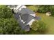 Aerial view showing the new roof of this suburban home, nestled amongst mature trees at 1604 Carnation Dr, Durham, NC 27703