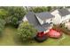 Aerial view of the home's new roof, large yard, and red back deck surrounded by mature trees at 1604 Carnation Dr, Durham, NC 27703
