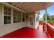 Back porch with glass door and a red painted wood floor at 1604 Carnation Dr, Durham, NC 27703