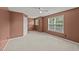 Spacious bedroom with neutral carpet, white trim, fan, and natural light from two windows at 1604 Carnation Dr, Durham, NC 27703