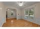Dining room with wood floors, white wainscoting, and a large window providing an abundance of natural light at 1604 Carnation Dr, Durham, NC 27703