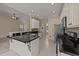 Open kitchen with tile floors, black countertops, stainless appliances, and a decorative island at 1604 Carnation Dr, Durham, NC 27703