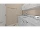 Functional laundry room with washer and dryer, cabinets, and hanging rack at 1604 Carnation Dr, Durham, NC 27703