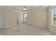 Neutral main bedroom with carpeting, tray ceiling, ceiling fan, and lots of natural light from a large window at 1604 Carnation Dr, Durham, NC 27703