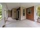 Welcoming front porch with brick accents, neutral siding, and concrete floor at 1604 Carnation Dr, Durham, NC 27703