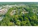 Wide aerial perspective reveals homes surrounded by lush greenery, complemented by serene community pond at 1605 Valley Run, Durham, NC 27707