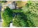 Aerial view showcases homes nestled among lush trees, featuring a backyard with a playground at 1605 Valley Run, Durham, NC 27707