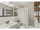 Well-lit bathroom with white subway tiles, open wooden shelves and a shower-tub combination at 1605 Valley Run, Durham, NC 27707