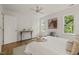 Bright bedroom featuring hardwood floors, a ceiling fan, and an artistic cow portrait at 1605 Valley Run, Durham, NC 27707