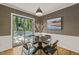 A modern dining room features wainscoting, grasscloth wallpaper, and views of the yard at 1605 Valley Run, Durham, NC 27707