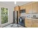 This kitchen features stainless steel appliances, wood cabinets, subway tile backsplash and a window with a beautiful view at 1605 Valley Run, Durham, NC 27707