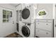 The laundry room boasts stacked washer and dryer, white cabinets, and stylish decor at 1605 Valley Run, Durham, NC 27707