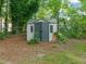 A storage shed with neutral tones that complements the natural surroundings and landscaping at 1605 Valley Run, Durham, NC 27707