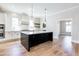 Bright kitchen featuring an island with dark cabinets, white backsplash and pendant lighting at 162 Farmstead Ct, Wendell, NC 27591