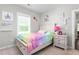 Cozy bedroom with window, colorful decor, and neutral carpet at 1711 Memory Ln, Burlington, NC 27217