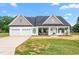Beautiful home with a covered porch, rocking chairs, swing, two-car garage, and lush green lawn at 1711 Memory Ln, Burlington, NC 27217