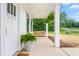 Welcoming front porch with a wooden swing, hanging plants, and views of the greenery outside at 1711 Memory Ln, Burlington, NC 27217