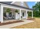 Inviting covered porch with hanging ferns, rocking chairs, and a swing for relaxing outdoors at 1711 Memory Ln, Burlington, NC 27217