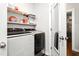 Well-equipped laundry room with modern washer and dryer, wire shelving, and a glimpse into another room at 1711 Memory Ln, Burlington, NC 27217