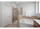 Bright bathroom features a shower, soaking tub, and large mirror at 1724 Capstone Dr, Durham, NC 27713