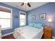 Cozy bedroom with natural light, calming blue walls, and hardwood floors at 1724 Capstone Dr, Durham, NC 27713