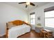Bright bedroom featuring hardwood floors, two windows, and a wooden bed at 1724 Capstone Dr, Durham, NC 27713