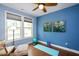 Bright bedroom with hardwood floors, ceiling fan, and blue accent walls with art at 1724 Capstone Dr, Durham, NC 27713