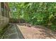 The backyard shows a stone fire pit and minimal grass space surrounded by lush foliage at 19 Knightsbridge Ct, Durham, NC 27707