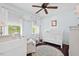 Bright bedroom features a white crib, rocking chair, dark wood floors, and a ceiling fan at 19 Knightsbridge Ct, Durham, NC 27707