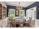 Elegant dining room featuring a round wooden table, wainscoting, and large windows with custom curtains at 19 Knightsbridge Ct, Durham, NC 27707