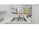 Well-lit kitchen features an undermount sink, white cabinets, stainless appliances, and breakfast bar with seating at 19 Knightsbridge Ct, Durham, NC 27707