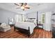 Spacious main bedroom features a tray ceiling, wood floors, a ceiling fan, and bright windows with privacy shades at 19 Knightsbridge Ct, Durham, NC 27707