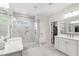 Bright bathroom featuring double vanity, glass shower with a window, and a door to a walk-in closet at 1928 Vandiver Way, Apex, NC 27523