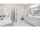 Bright bathroom with double vanity, quartz countertop and marble floors, with two entrances for accessibility at 1928 Vandiver Way, Apex, NC 27523
