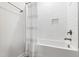 Well-lit bathroom showcasing a clean white tub and shower with modern fixtures and tiled walls at 1928 Vandiver Way, Apex, NC 27523