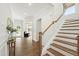 Bright foyer featuring hardwood floors, a staircase, and views into the living room, creating an inviting entrance at 1928 Vandiver Way, Apex, NC 27523