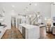 Bright kitchen showcasing an island, stainless appliances, and an open floor plan leading to the stairs at 1928 Vandiver Way, Apex, NC 27523