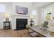 Living room features a fireplace, hardwood floors, and large windows with natural light at 1928 Vandiver Way, Apex, NC 27523
