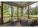 Inviting screened porch with comfortable seating and serene views of the surrounding trees at 1928 Vandiver Way, Apex, NC 27523