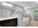 Bathroom featuring double sinks, dark wood cabinetry, and a large tub at 20 Sugarpine Trl, Clayton, NC 27520