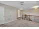 Carpeted hallway showcasing wood railings and a door leading to the other rooms at 20 Sugarpine Trl, Clayton, NC 27520