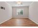 Empty bedroom features modern ceiling fan, hardwood floors and a bright window at 202 Verrazano Pl, Clayton, NC 27520