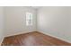 This bedroom has wood floors, neutral walls, and a window with lots of natural light at 202 Verrazano Pl, Clayton, NC 27520